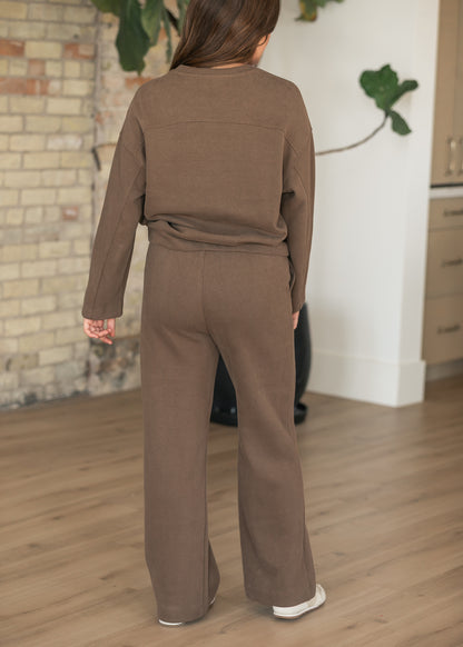 Back of brown wide leg jogger pants showing relaxed fit and full-length silhouette, styled with matching pullover.