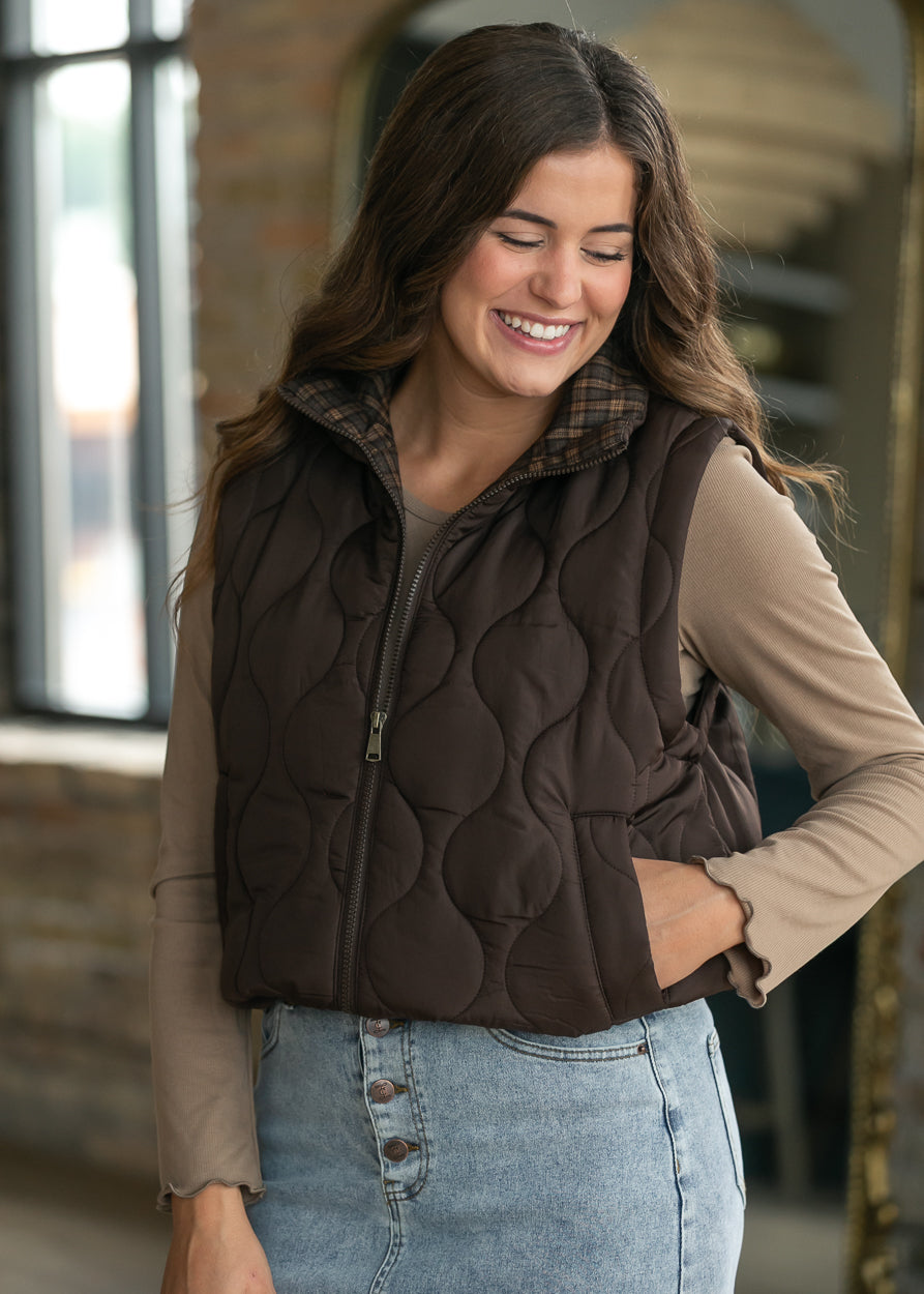 Brown quilted vest styled with a denim maxi skirt