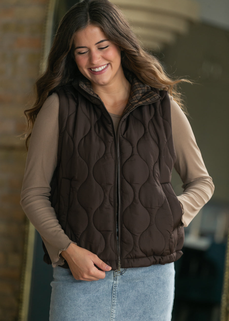 Brown quilted vest styled over a taupe long sleeve top