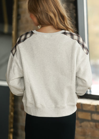 Back of white mélange sweatshirt showing plaid shoulder panels, long sleeves, and ribbed hem.