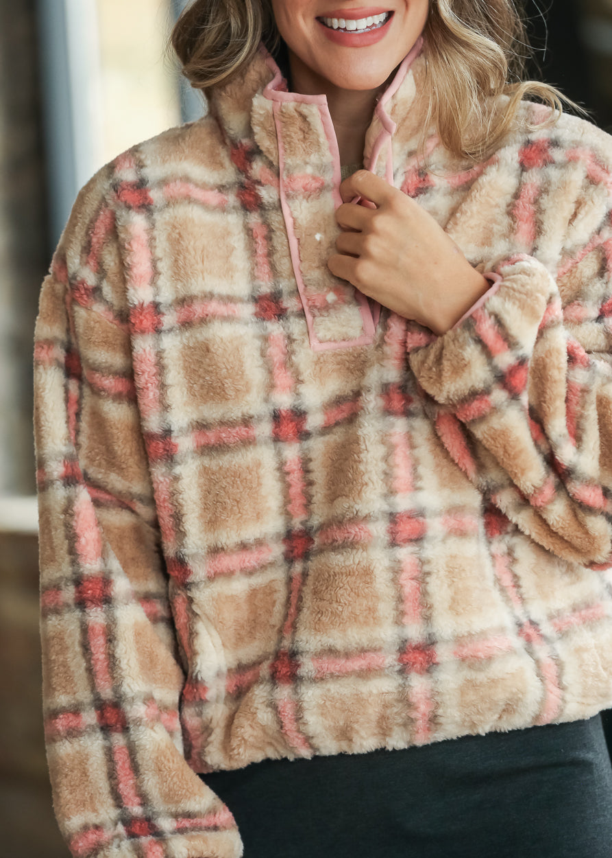 Close-up of plush plaid sherpa fleece texture with pink-trimmed collar