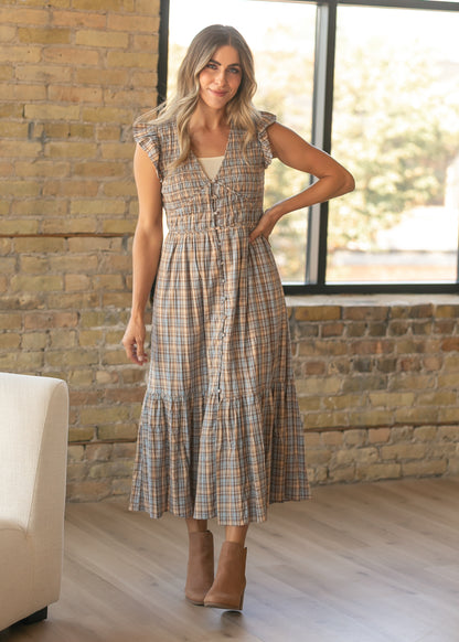 Brown and muted blue plaid maxi dress with a smocked bodice, V-neckline, and covered button detail.