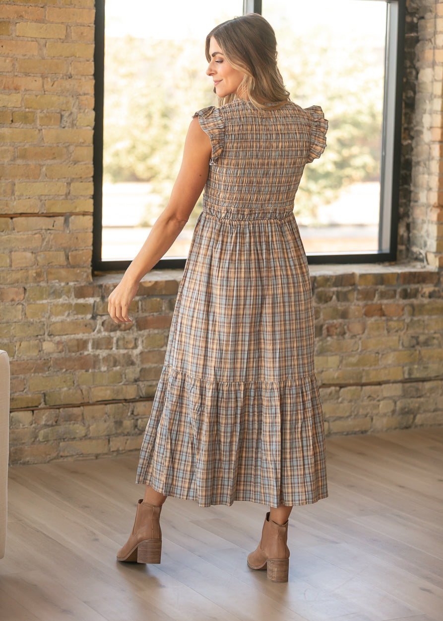 Back of plaid maxi dress showing the smocked bodice, flutter sleeves, and tiered ankle-length skirt.