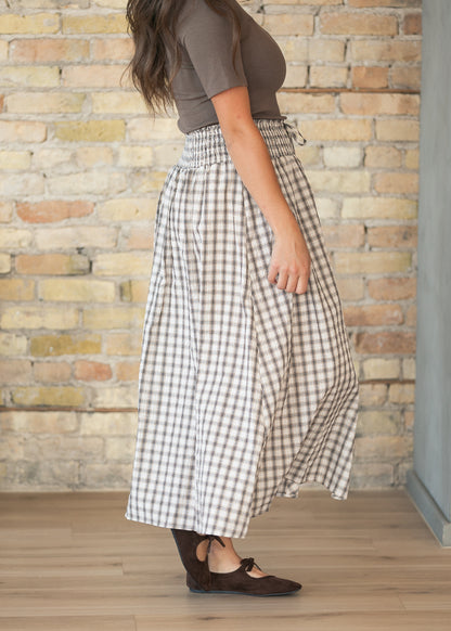Side view of cream plaid midi skirt showing the gathered A-line silhouette and smocked waist.