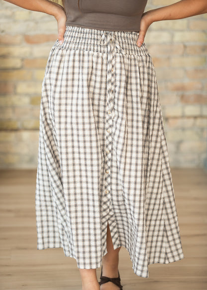 Cream plaid midi skirt with decorative button front and softly flowing A-line shape.