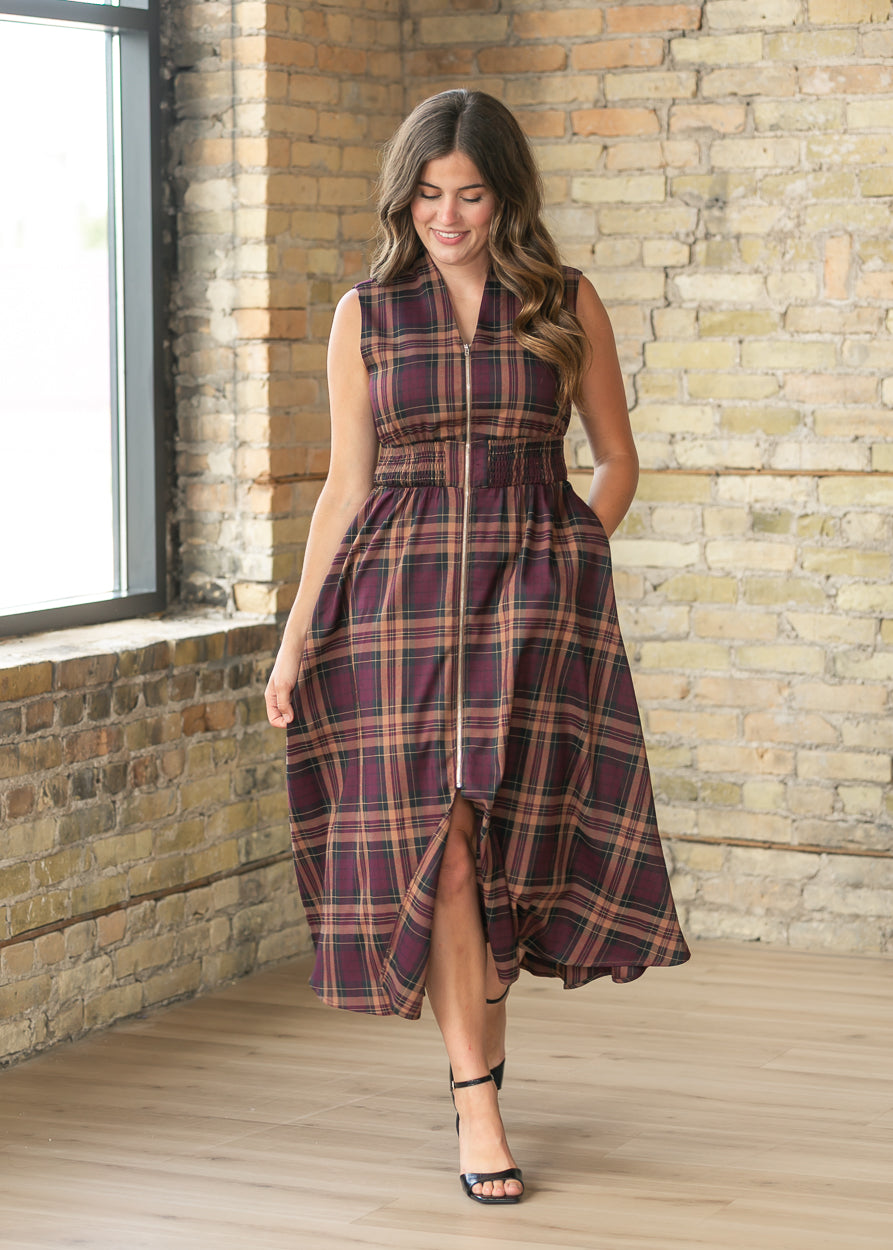 Plaid zipper front maxi dress with pockets and flowing skirt in motion.