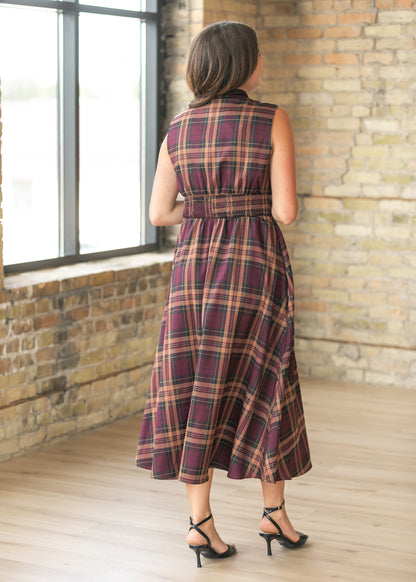 Back of plaid maxi dress showing the smocked waist and flowing full-length skirt.
