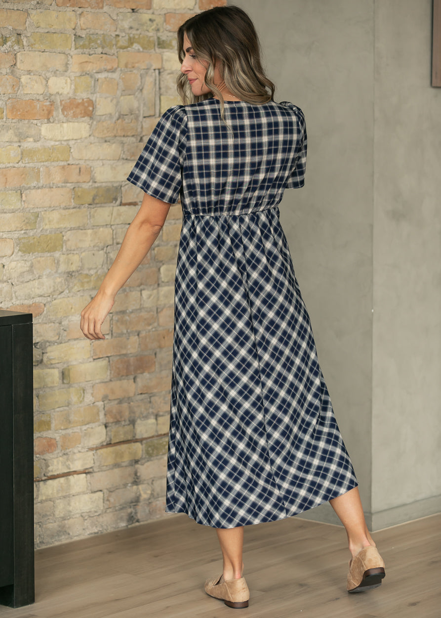 Navy plaid V-neck midi dress with short sleeves and a gathered waist, shown from the back.