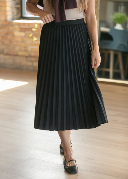 Black pleated midi skirt with stretchy waistband, styled with cream top and maroon cardigan.