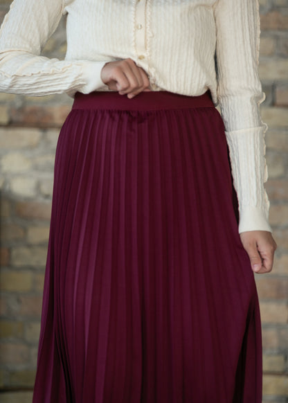 Close-up of burgundy pleated fabric construction and pleat definition.