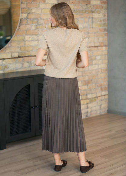 Back view of cocoa pleated midi skirt showing pleated construction and fit.