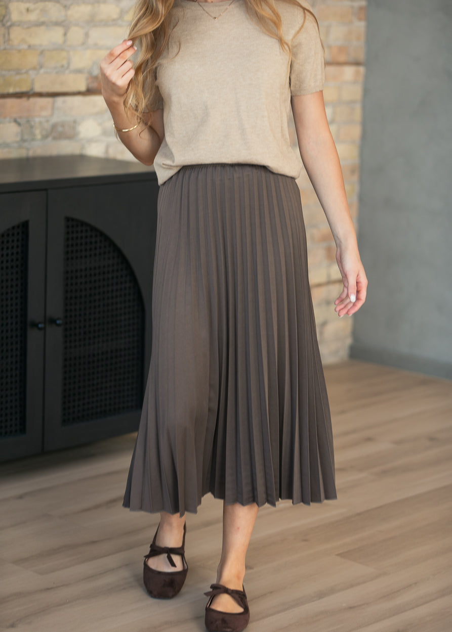 Front view of cocoa pleated midi skirt showing A-line silhouette and mid-calf length.