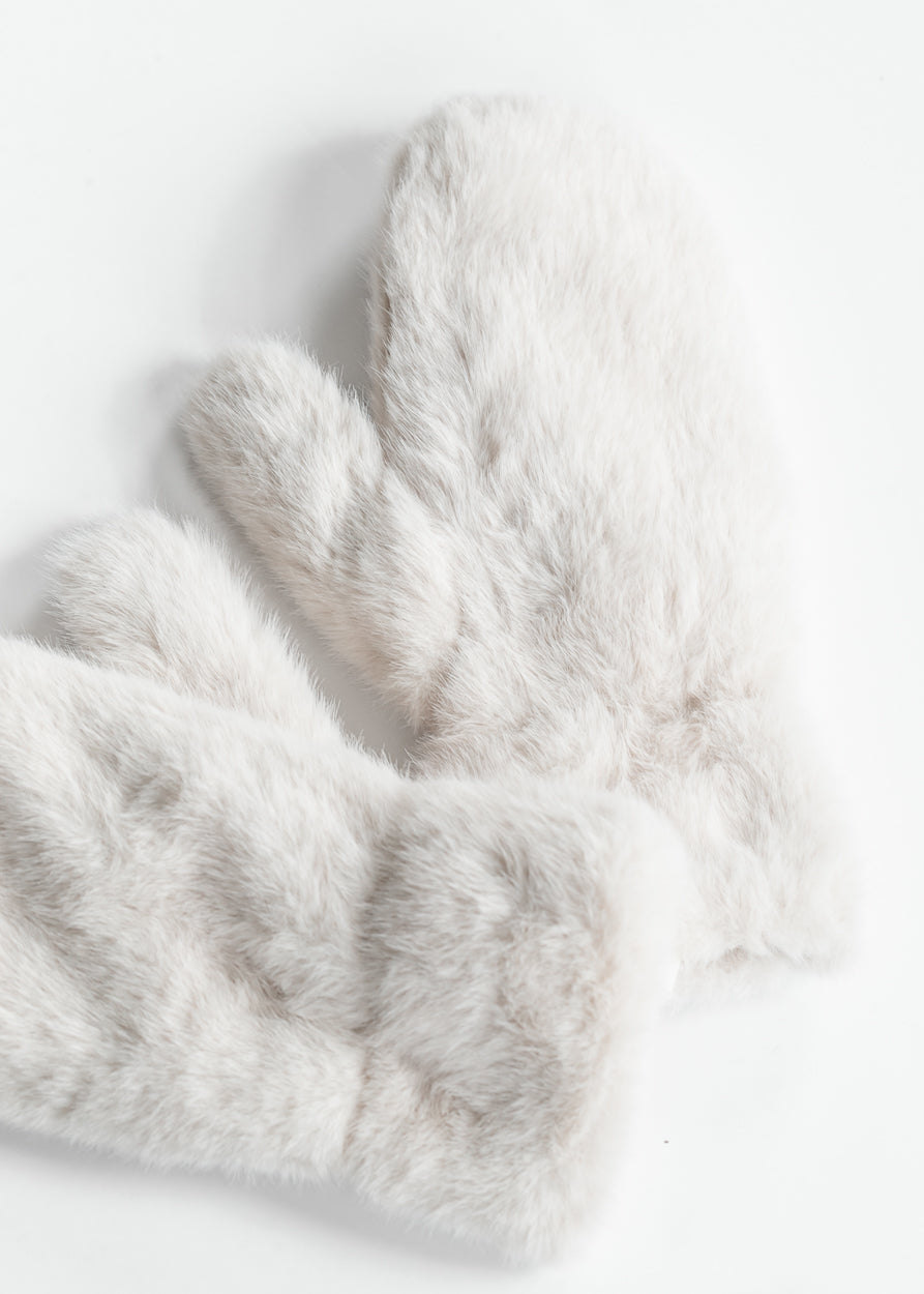 Ivory faux fur mittens styled with a neutral scarf and brown button-front coat.