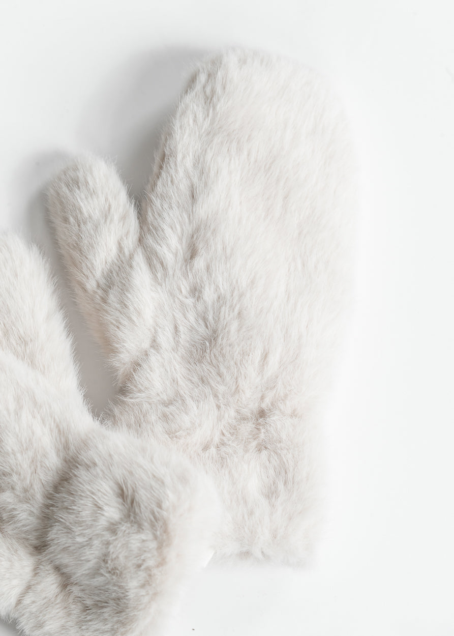 Close-up of ivory-grey faux fur mittens showing soft fluffy texture.