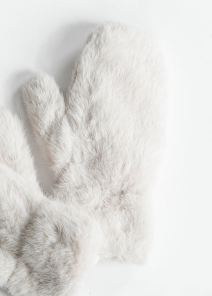 Close-up of ivory-grey faux fur mittens showing soft fluffy texture.