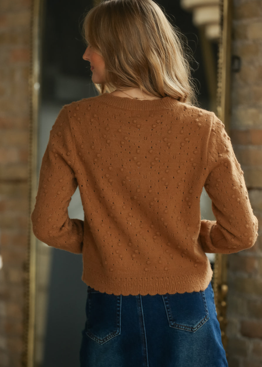 Back view of camel bobble knit cardigan showing the pointelle texture and waist-length hem.