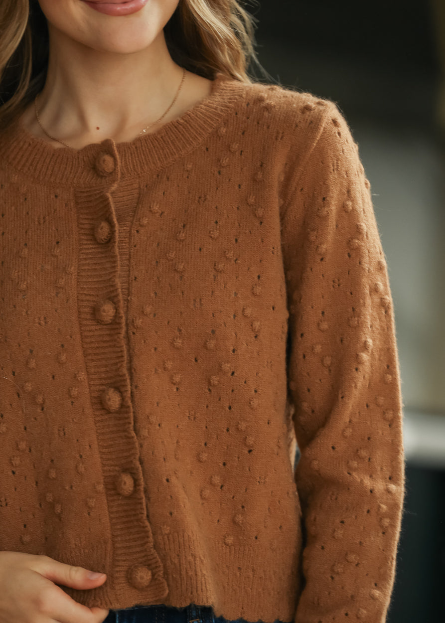 Camel pointelle bobble knit cardigan with tonal buttons and textured openwork detail.