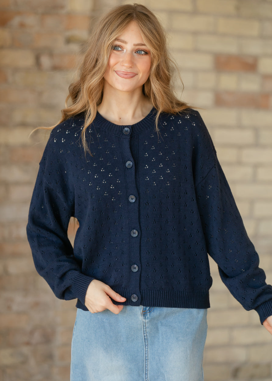 Navy pointelle cardigan featuring small openwork knit details and coordinating navy buttons down the front.