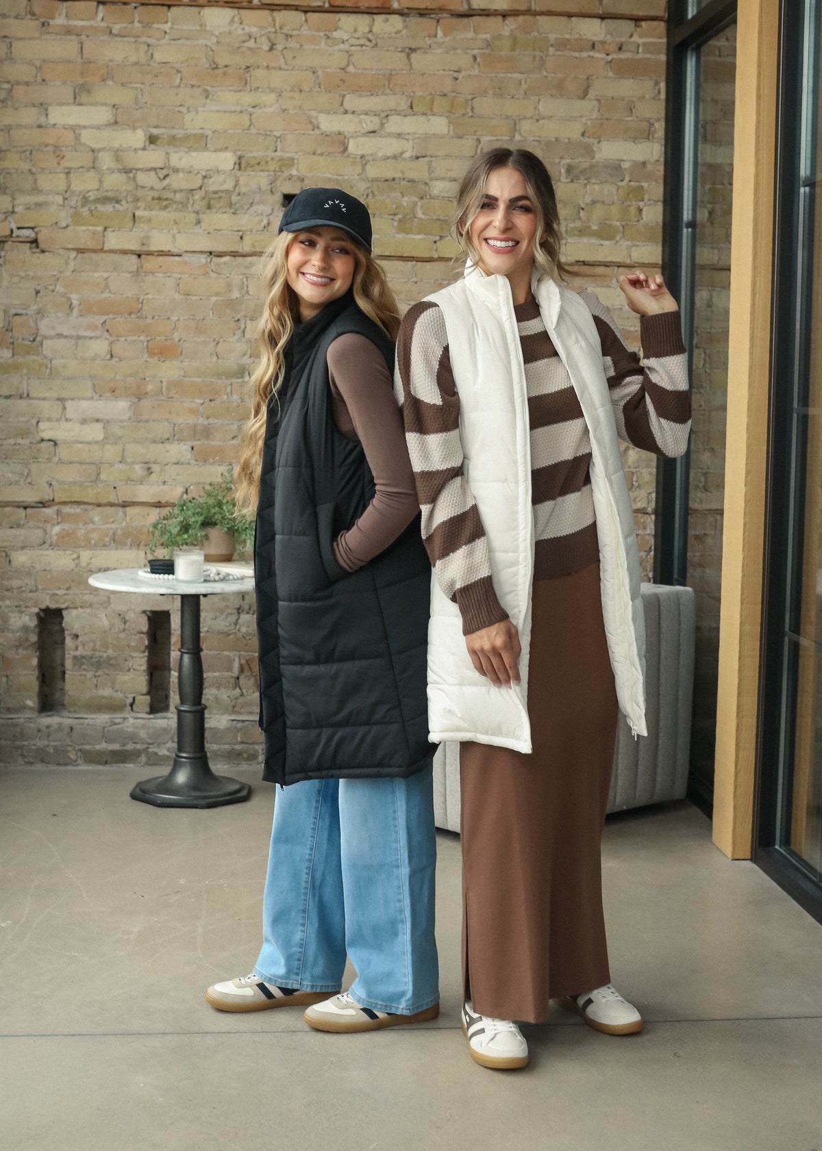 Black Polar long puffer vest with quilted construction and side pockets, layered over a gray dress.
