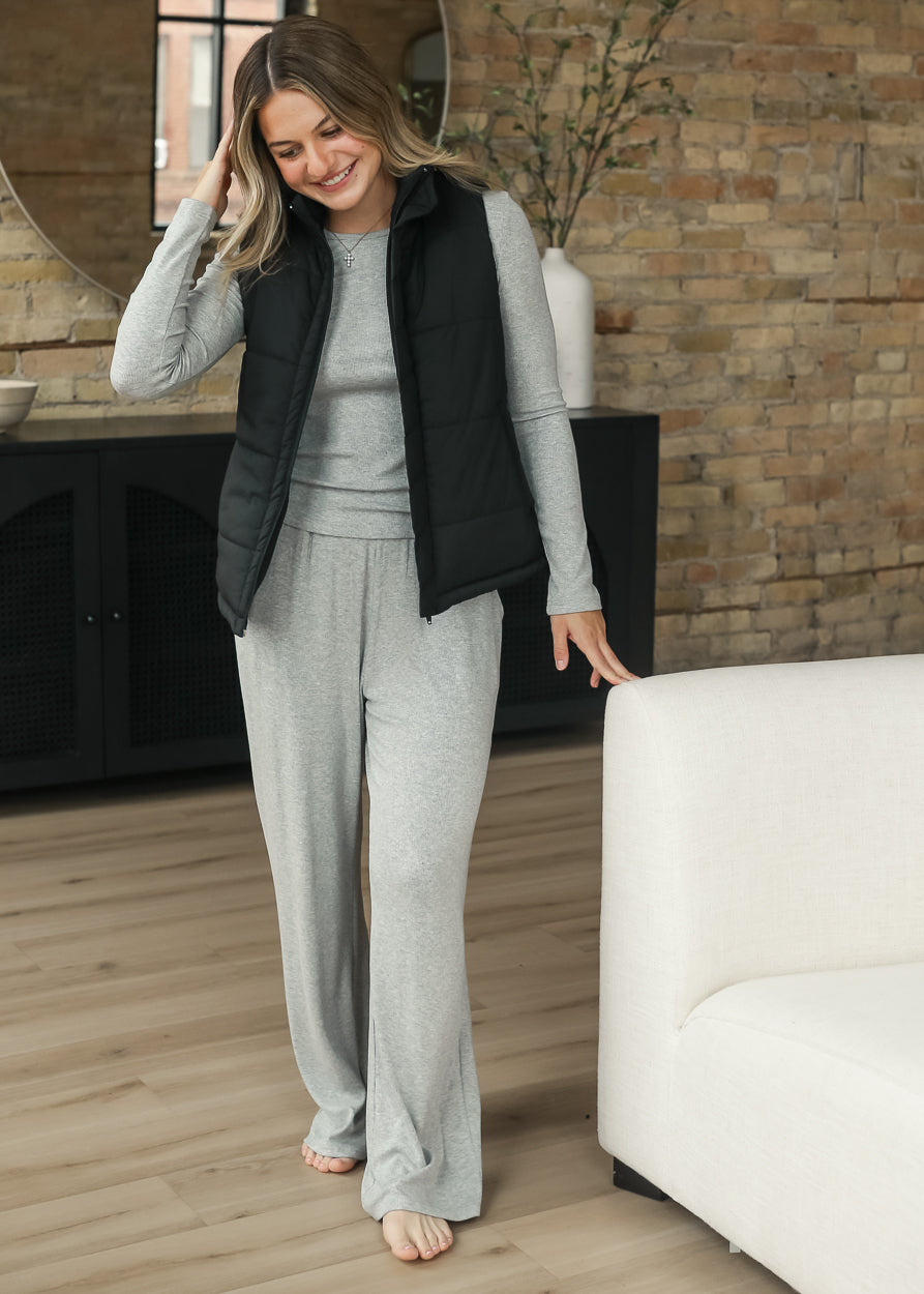 Full-length black puff vest layered over a gray matching set.