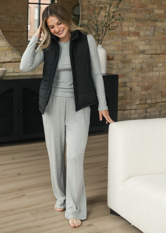 Full-length black puff vest layered over a gray matching set.