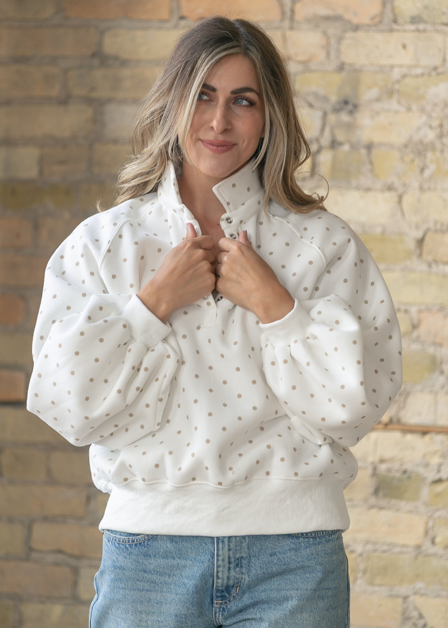 Ivory polka dot quarter snap pullover with oversized fit and balloon sleeves.