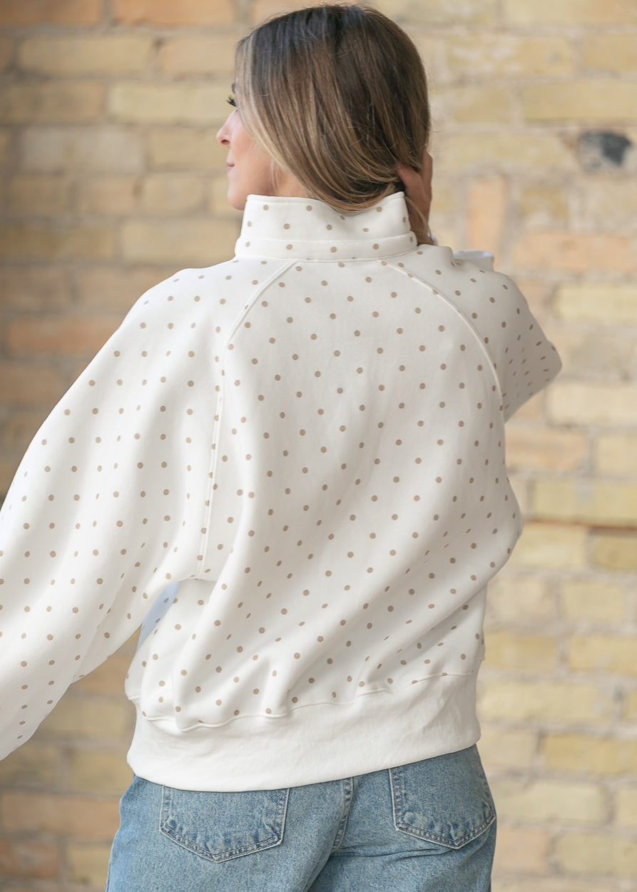 Back view of ivory polka dot pullover showing relaxed oversized silhouette.