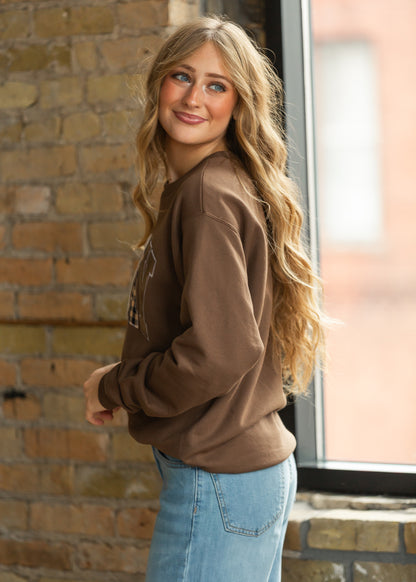 Side view of brown PRAY sweatshirt with long sleeves and ribbed trim