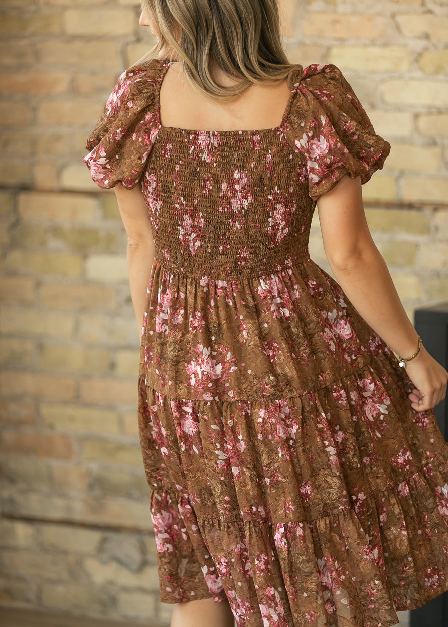 Brown floral chiffon midi dress with smocked bodice, square neckline, puff sleeves, and tiered skirt.