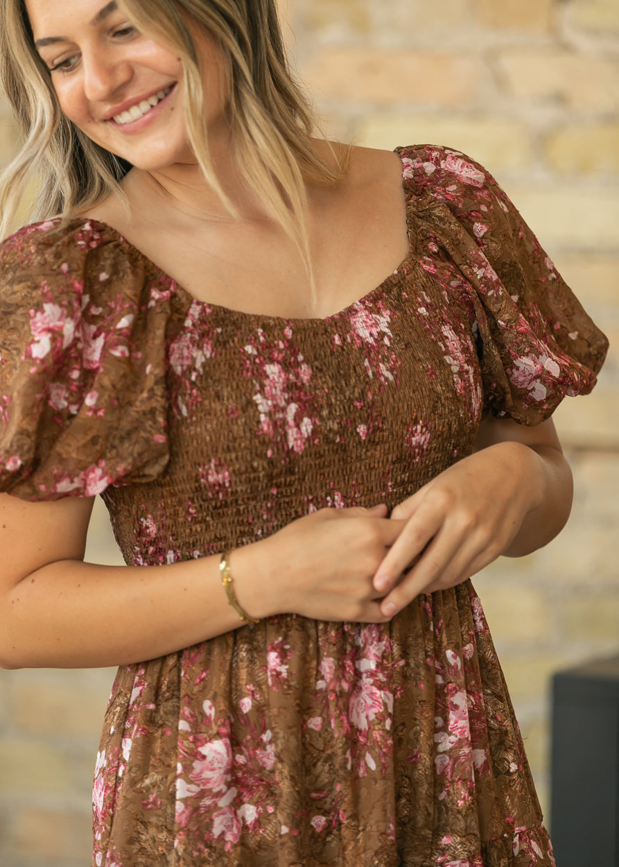 Close-up of brown floral chiffon dress showing the square neckline, smocked bodice, and sheer puff sleeves.