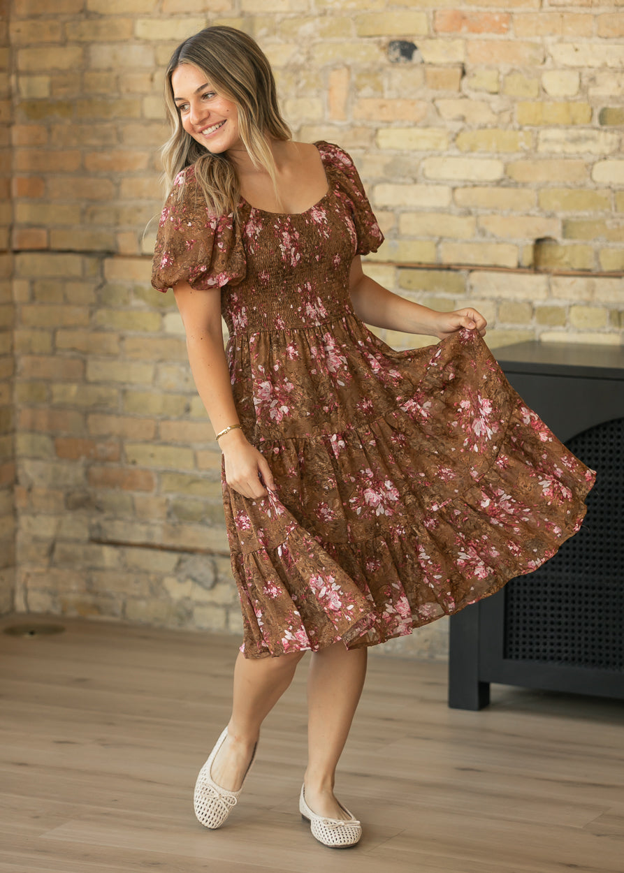 Brown floral midi dress with tiered skirt shown in motion with cream woven flats.