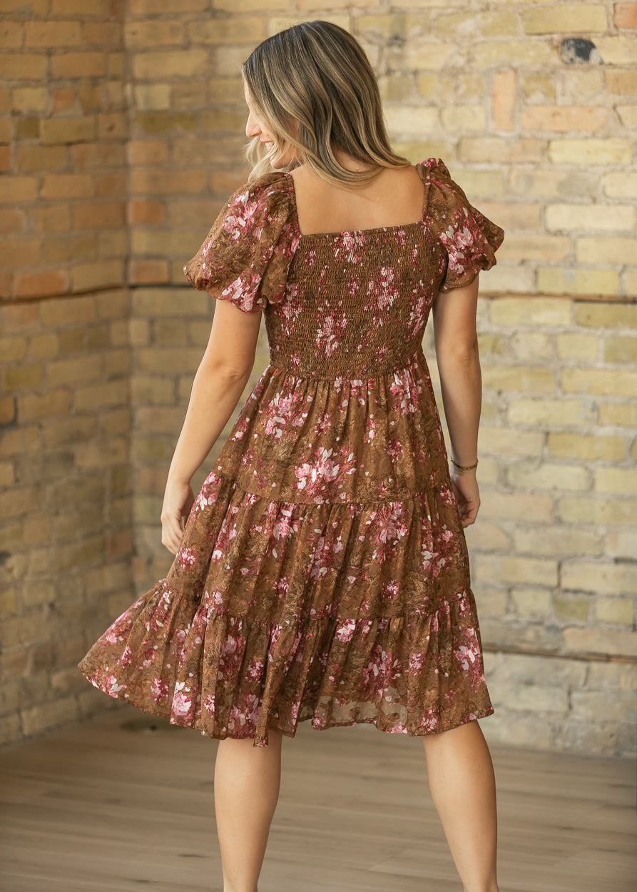 Back of brown floral midi dress showing the stretchy smocked bodice and tiered chiffon skirt.