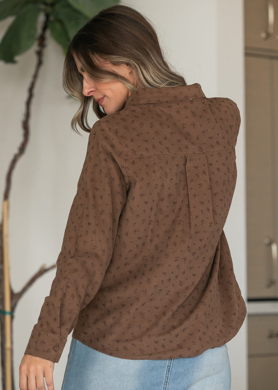 Brown corduroy button-up shirt with delicate floral pattern, back yoke seam, and rounded hem.