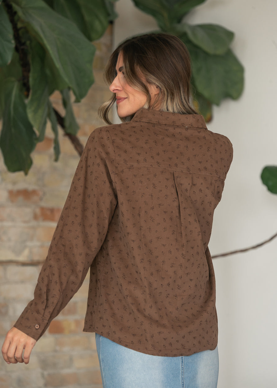 Back of brown floral print corduroy top showing long sleeves, back pleat, and relaxed silhouette.