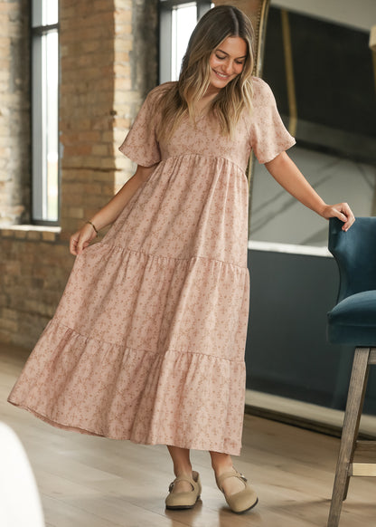 Dusty pink floral maxi dress with sweetheart neckline and tiered skirt, styled with neutral flats.