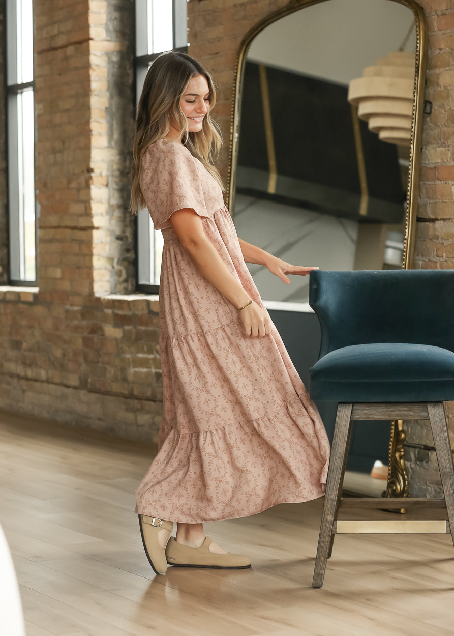 Side view of dusty pink floral maxi dress showing flutter sleeves and loose tiered silhouette.