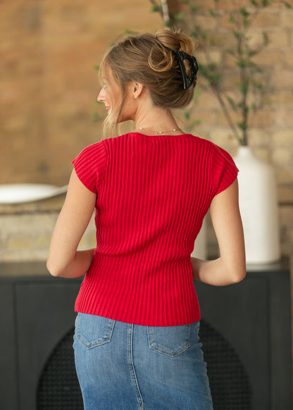 Back of red ribbed cap sleeve top showing the fitted hip-length shape, styled with a denim skirt.