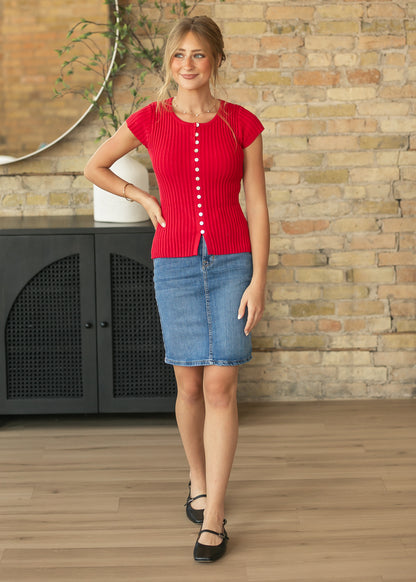 Front view of red ribbed cap sleeve top showing the fitted hip-length cut and contrast buttons.