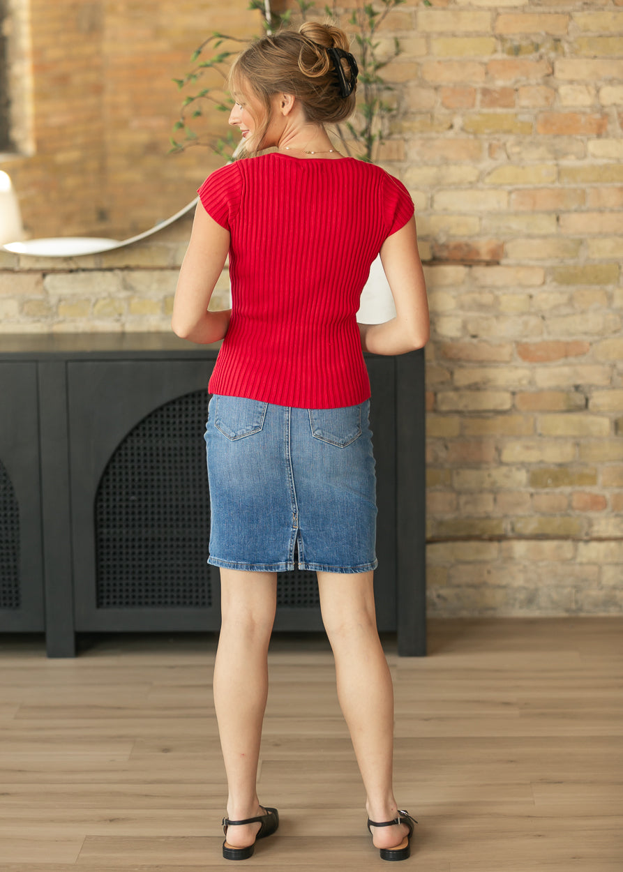 Full back view of red ribbed cap sleeve top with vertical ribbing, paired with a knee-length denim skirt.