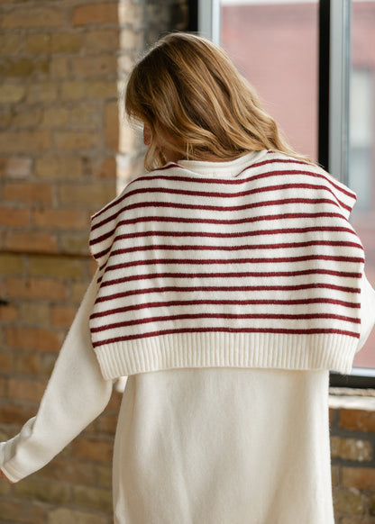 Close-up of cream and red striped shawl layered over a cream sweater dress.