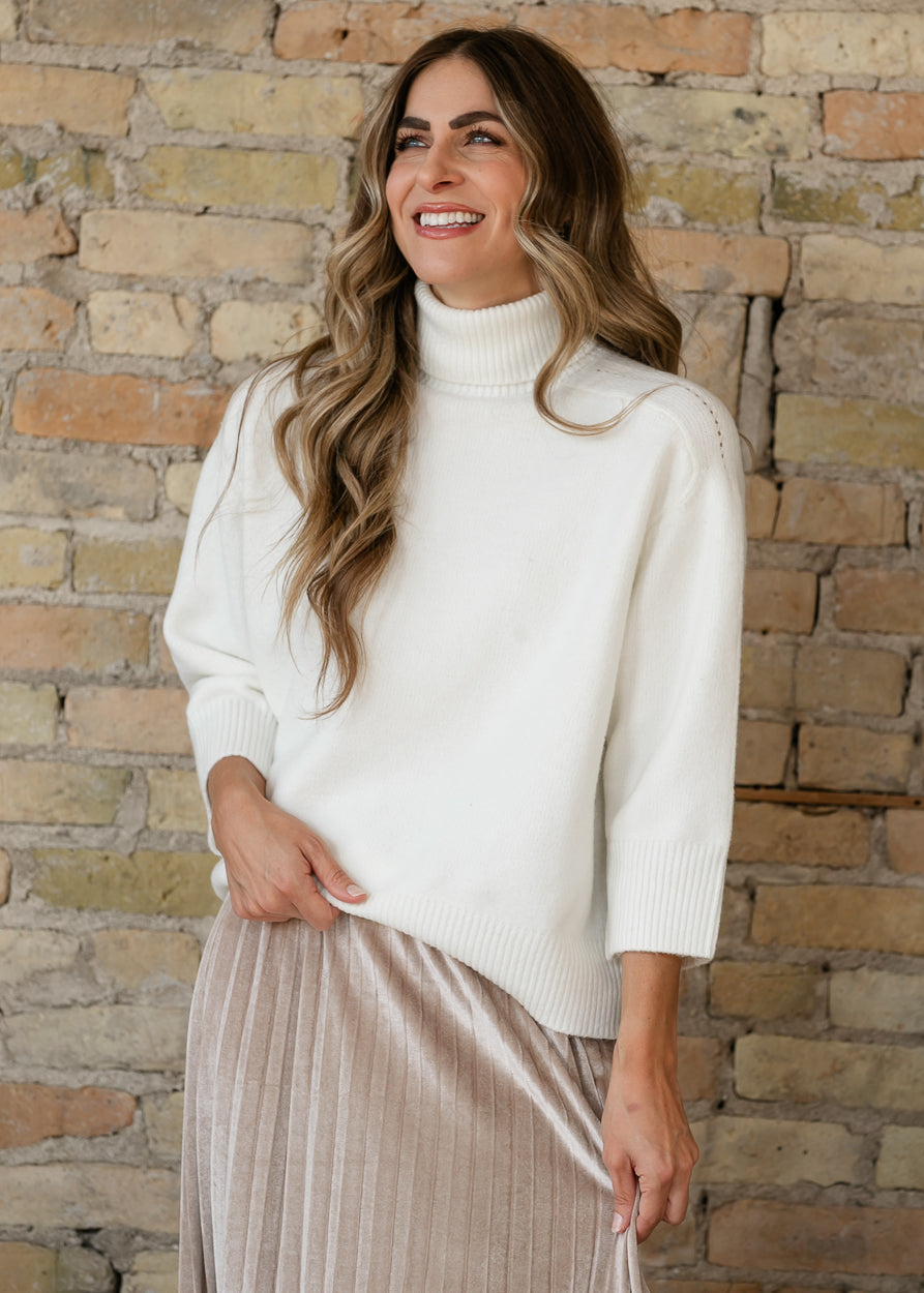 Steve Madden Arlette almond sweater featuring a ribbed funnel neckline, three-quarter sleeves, and soft knit texture.