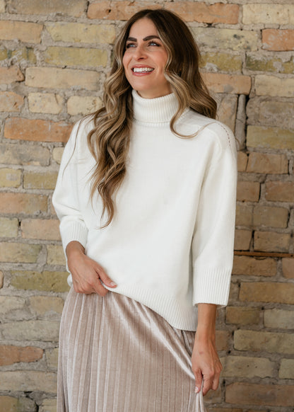 Steve Madden Arlette almond sweater featuring a ribbed funnel neckline, three-quarter sleeves, and soft knit texture.