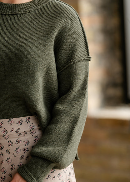 Olive green drop shoulder sweater with exposed seam details and ribbed crew neckline.