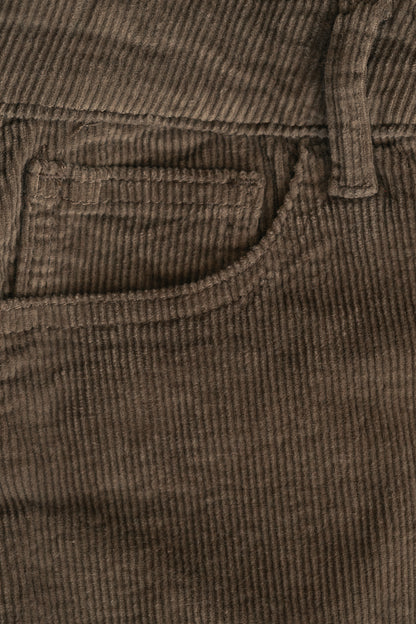 Close-up of brown corduroy pants showing a pocket and ribbed fabric texture.