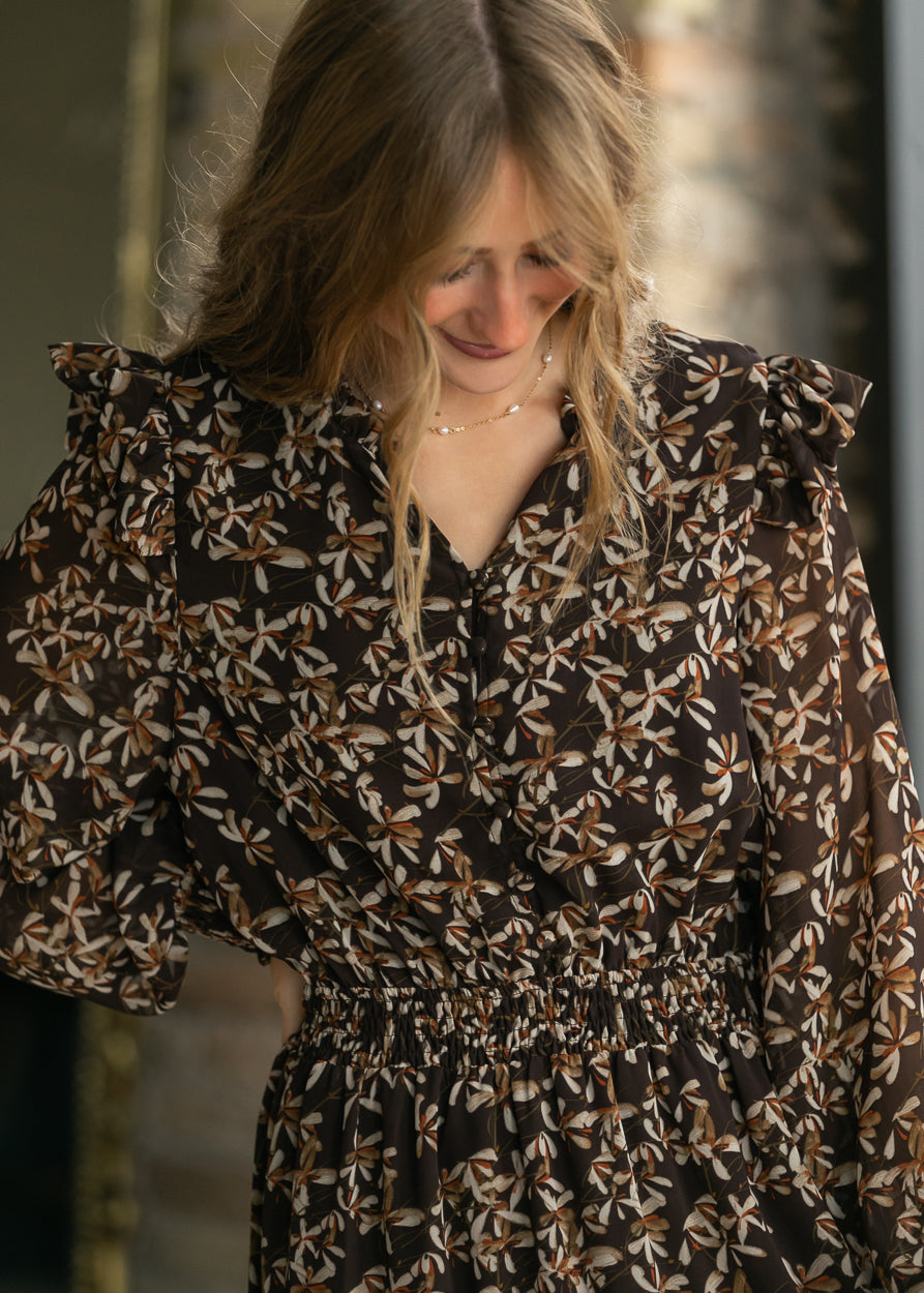 Close-up of Remington brown floral maxi dress showing the button neckline, floral print, and smocked waist.
