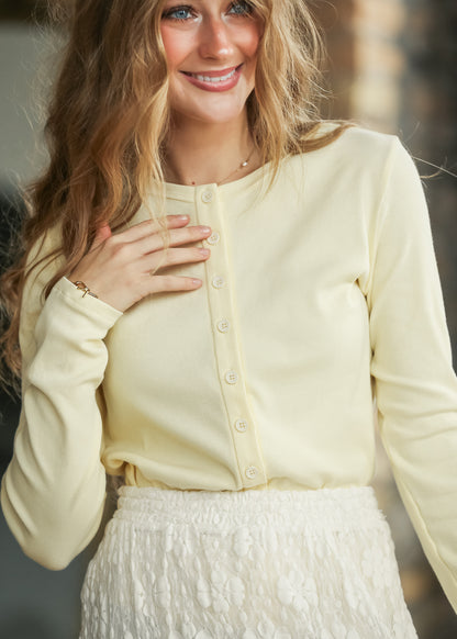 Front view of butter button front knit top with a fitted silhouette and long sleeves.