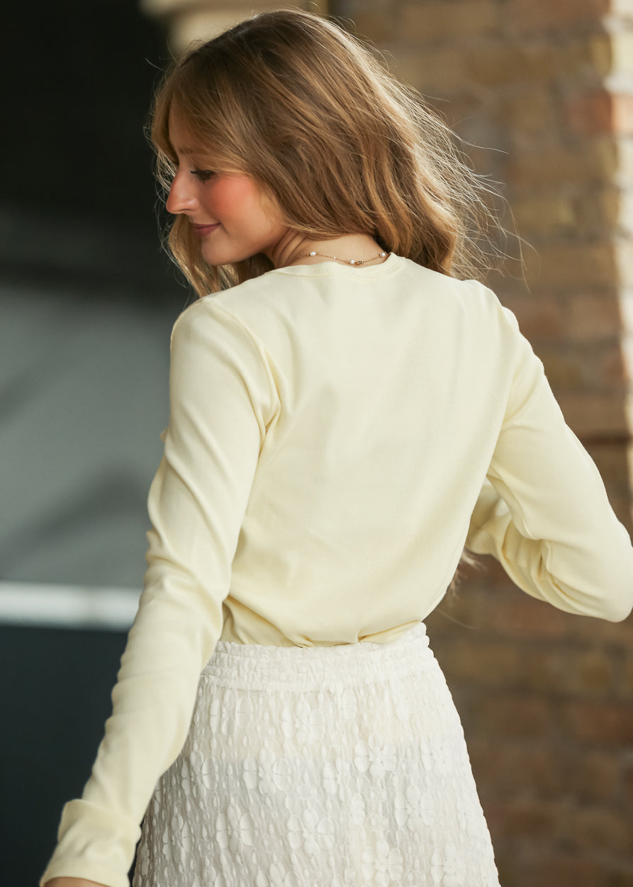 Back detail of the butter fitted ribbed knit top with a simple crew neckline.