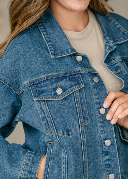 Close-up back view of medium wash denim jacket showing collar, shoulder seams, and classic denim stitching.