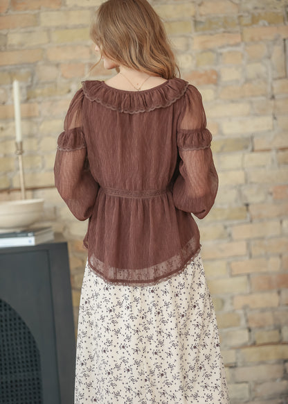 Back view of brown ruffle long sleeve top with ruffled scoop back, lace trim, and sheer lace-edged hem in crinkle fabric.