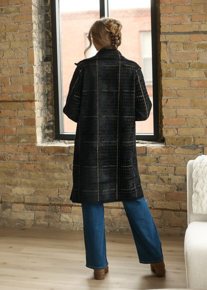 Full back view of black multi houndstooth coat showing the longline shape and warm neutral pattern.